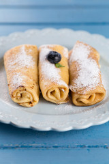 Three homemade rolled pancakes with blueberry