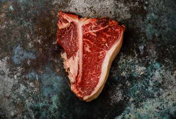 Raw fresh meat Hand selected Prime Dry Aging Steak T-bone on metal background