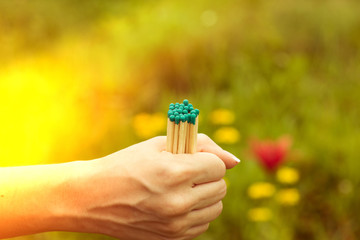 Several matches in a woman's hand with a light