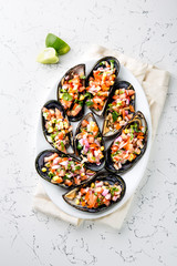 PERUVIAN FOOD. Choros a la chalaca. Big mussels, choros zapatos seasoned with purple onion, tomatoes, corn and lemon. Top view, white background. Traditional peruvian dish