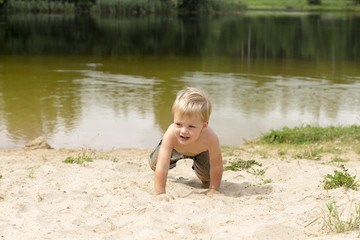 Little baby boy playing on beach. Summer water fun