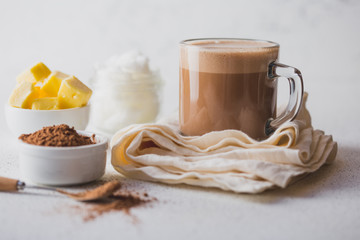 BULLETPROOF CACAO. Ketogenic keto diet hot drink. Cacao blended with coconut oil and butter. Cup of bulletproof cacao and ingredients on white background