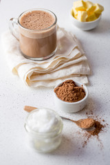 BULLETPROOF CACAO. Ketogenic keto diet hot drink. Cacao blended with coconut oil and butter. Cup of bulletproof cacao and ingredients on white background