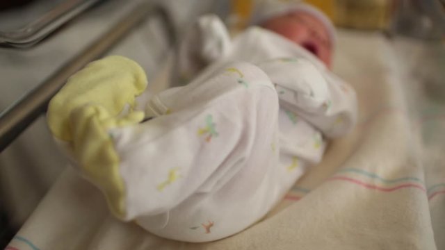 Newborn Baby in Hospital Kicking in Bassinet