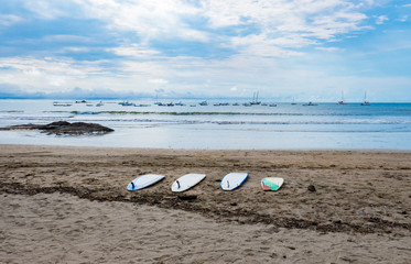 Fototapeta na wymiar Four surfboards laying on the sand waiting for the surf to improve at a Costa Rican beach in Central America.
