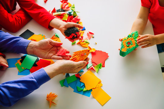 teacher and kids making origami crafts with paper
