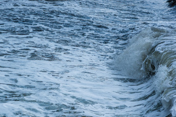 pebble stones on the sea beach, the rolling waves of the sea with foam