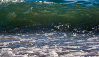 sea landscape is a pebbly beach with waves in white foam