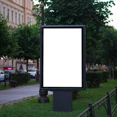 Fototapeta premium light poster billboard standing in the street in the summer. layout for advertising white. Vertical blank glowing billboard on the city street Mock up