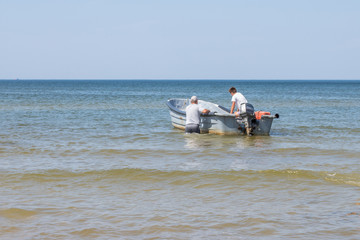 Fototapeta na wymiar fishermen in a boat sail into the sea