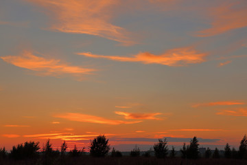 Obraz premium Beautiful orange bright sunset with blue sky and wonderful clouds