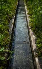 Oak wooden gutter for water supply. Decorative well