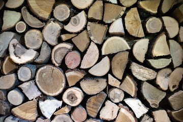Natural wooden logs cut and stacked in pile, felled by the logging timber industry, Abstract photo of a pile of natural wooden logs background