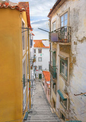 Fototapeta na wymiar A small street with stairs in Alfama. Lisbon, Portugal