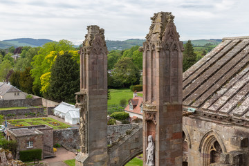 Fototapeta premium Aerial view from ruins of Melrose abbey to courtyard with garden in Scottish highlands