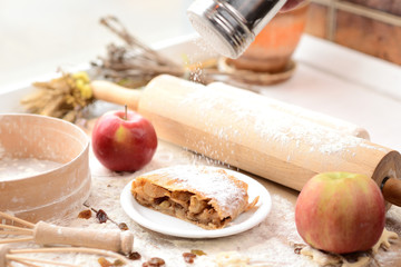 strudel (roll strudel) with apple on a wooden board with flour