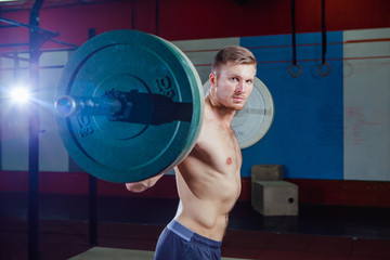Muscular fitness man preparing to deadlift a barbell over his head in modern fitness center.Functional training.Snatch exercise. Cross style fit, deadlift