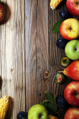 Various fresh fruits. Thanksgiving pumpkin, apples, and maize on rustic background.