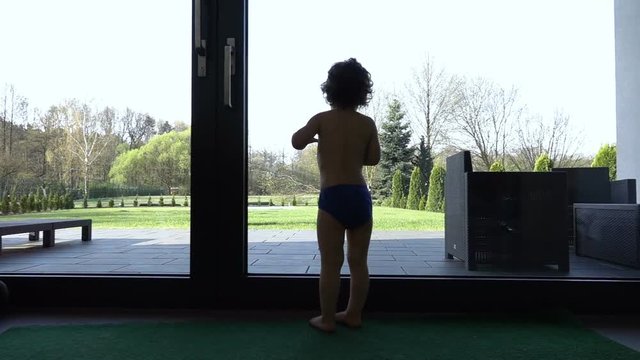 Silhouette oy baby boy looking out of the window, slow motion shot at 240fps
