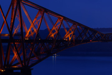 Close up photo of a historic iron bridge at night