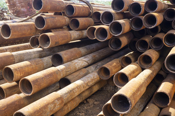 Oil Drill pipe. Rusty drill pipes were drilled in the well section. Downhole drilling rig. Laying the pipe on the deck. View of the shell of drill pipes laid in courtyard of the oil and gas warehouse.