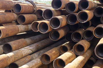 Oil Drill pipe. Rusty drill pipes were drilled in the well section. Downhole drilling rig. Laying the pipe on the deck. View of the shell of drill pipes laid in courtyard of the oil and gas warehouse.