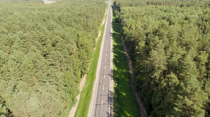 Aerial view flying over two lane forest road