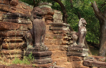 Fototapeta na wymiar Ancient stone lions statues in Angkor Wat temple complex in Siem Reap of Cambodia. Travel and sightseeing in Asia.