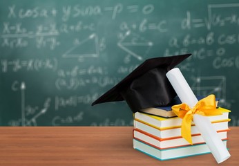 Graduation mortarboard on of stack books