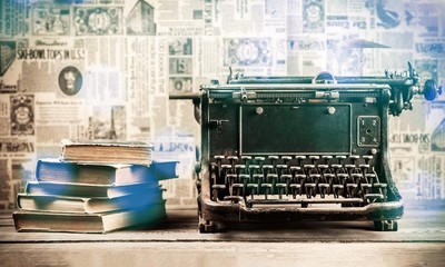 Old typewriter with books on background