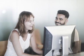 Junges Paar im Büro lachend