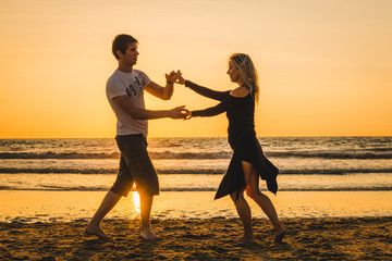Beautiful silhouettes of dancers at sunset