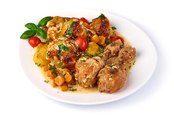 Roasted chicken legs with baked potatoes and vegetables, isolated on white background.