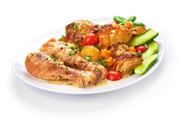 Roasted chicken legs with baked potatoes and vegetables, isolated on white background.