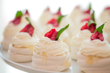 Close up of Pavlova dessert with forest fruit and mint on white background