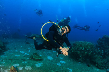 SCUBA diver swimming along a tropical coral reef