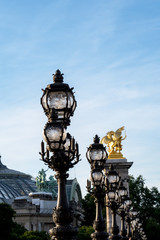 Fototapeta na wymiar Close-up of Art Nouveau lamps on Pont Alexandre III bridge - Paris, France