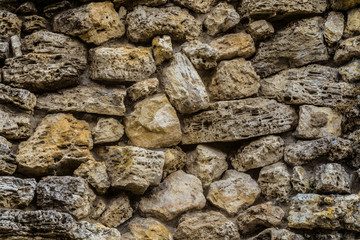 Black granite wall texture. Background of an old weathered granite stones.