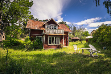 Fototapeta na wymiar Small red house in a small island during Midsummer in the Swedish Archipelago, Sweden