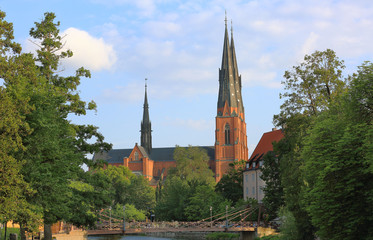 Fototapeta na wymiar Amazing view on old historical cathedral castle with green trees on front and blue sky on background. Uppsala, Sweden, Europe. Beautiful backgrounds/ wallpapers. 