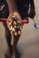 Detail of the hand of a cockles harvester in the beach in the island of Orango, Guinea Bissau, at sunset.