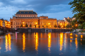 Prague National Theatre by night. Illuminated embankment and Vltava River. Prague, Czech Republic.