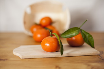 Mandarin orange fruits in wood basket on counter with leafs for healthy nutrition with vitOrange mandarin fruits in wood basket on counter with leafs for healthy nutriotion with vitramin camin c