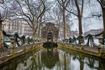 Fototapeta na wymiar Medici Fountain at the Luxembourg Palace garden in a freezing winter day day just before spring
