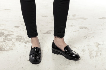 woman wearing black enamel shoes isolated white.
