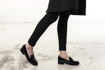 woman wearing black enamel shoes isolated white.