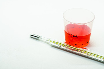 Thermometer and medicine isolated on white background