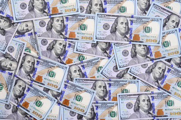 A large number of US dollar bills of a new design with a blue stripe in the middle. Top view