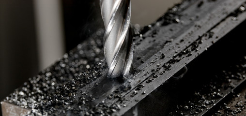 Bridgeport CNC end mill finishing a stack of steel plate with metal filings chips around