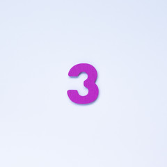 Wooden number 3 with purple color on white background.